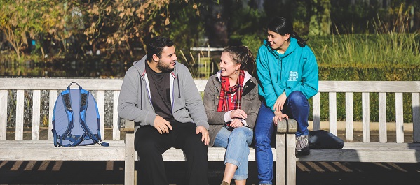 A mentor and two mentees chatting by the lake.