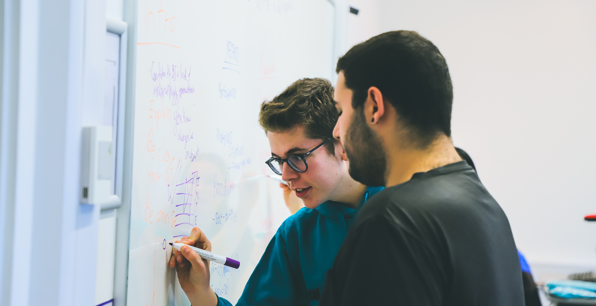 Student trainer running an activity on a whiteboard