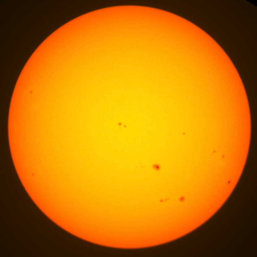 Centered colour photo of the sun. Some sunspots are visible.